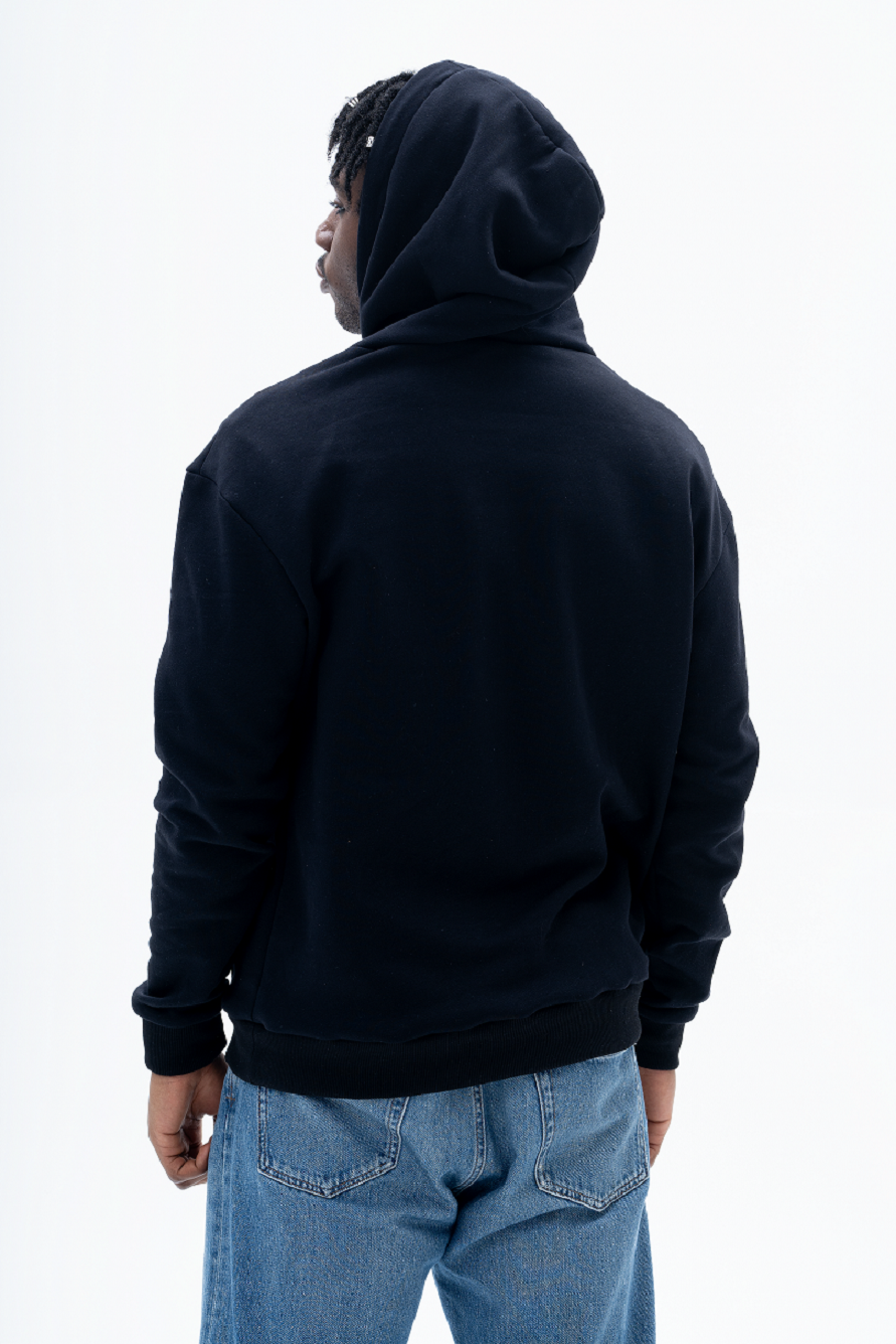 Model wearing AKANTARA Alien Print Hoodie in black, styled with casual streetwear