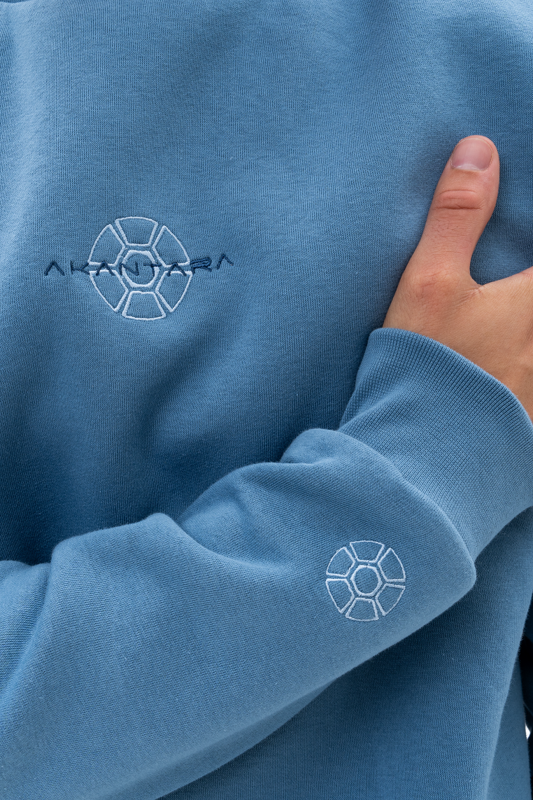 Embroidered OG AKANTARA logo on the chest and right cuff of the crewneck sweatshirt